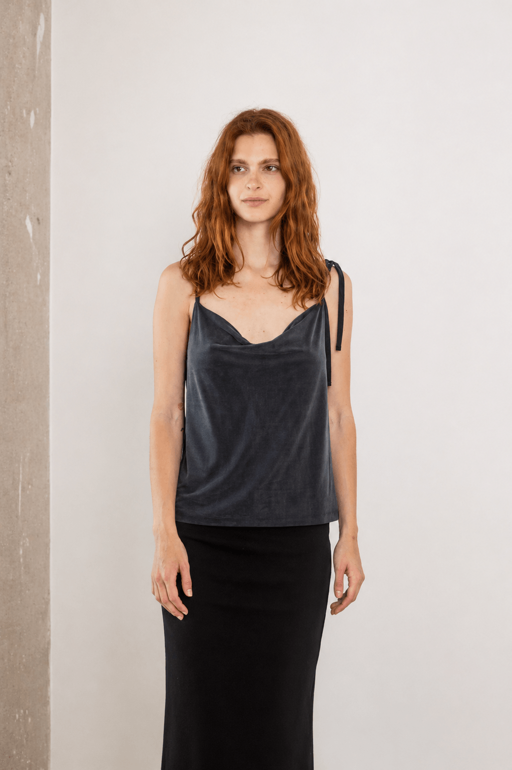Cupro Drape Slip Top in Soft Olive worn with a black skirt, showcasing adjustable straps and a flattering design.