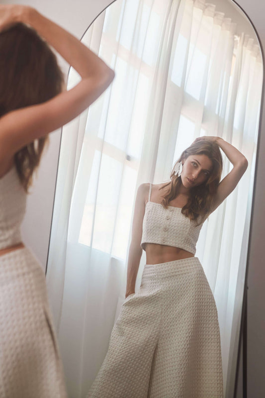 ECRU WAFFLE CROP TOP worn by a model in front of a mirror, showcasing its airy design and adjustable straps.
