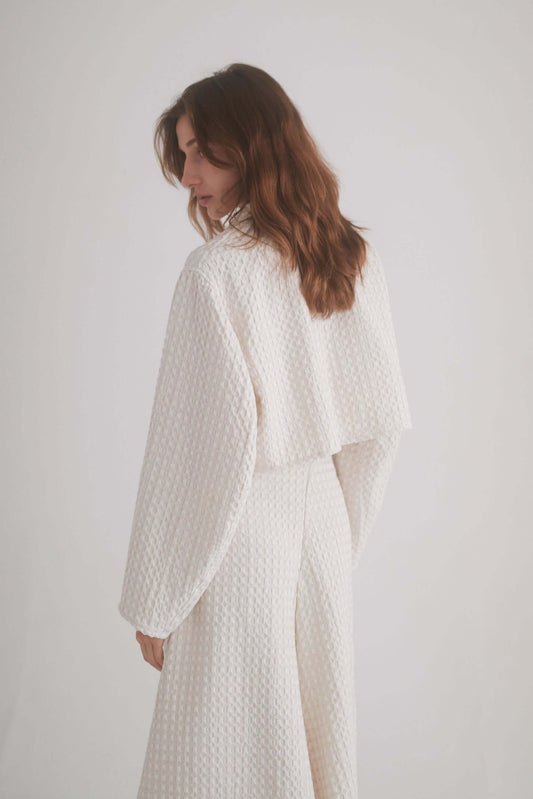 ECRU WAFFLE CROP JACKET featuring a model showcasing the lightweight design and waffle texture from the back.