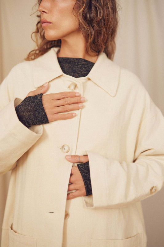 Woman wearing Oat Organic Cotton Long Wide Coat, showcasing its oversized fit and eco-friendly buttons.