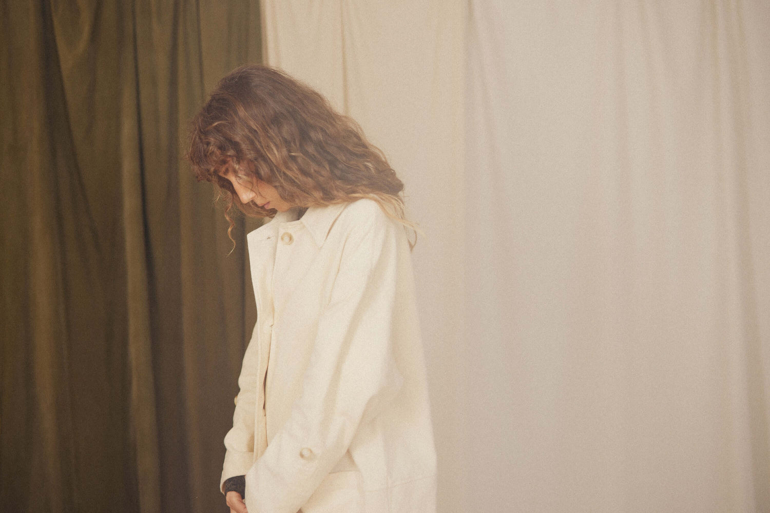 Model wearing a stylish cream coat from the WOMEN'S OUTERWEAR collection.