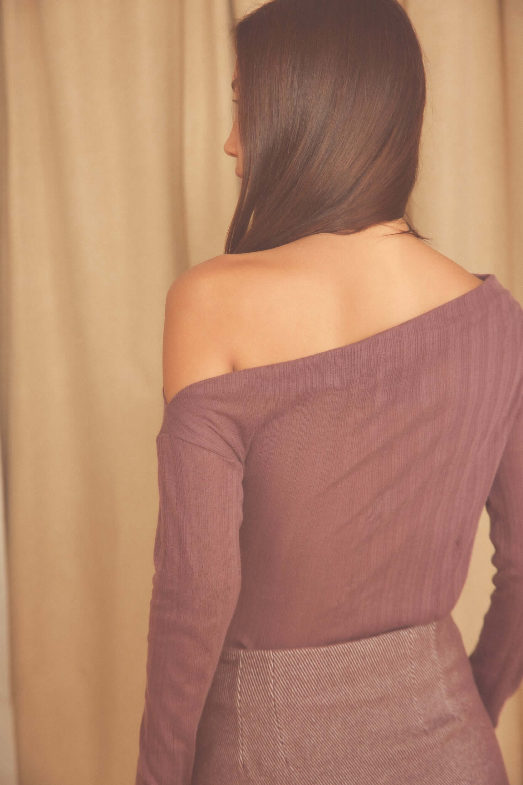 Back view of a model wearing the Cocoa Lyocell Ribbed Drape Bodysuit in soft cocoa brown.