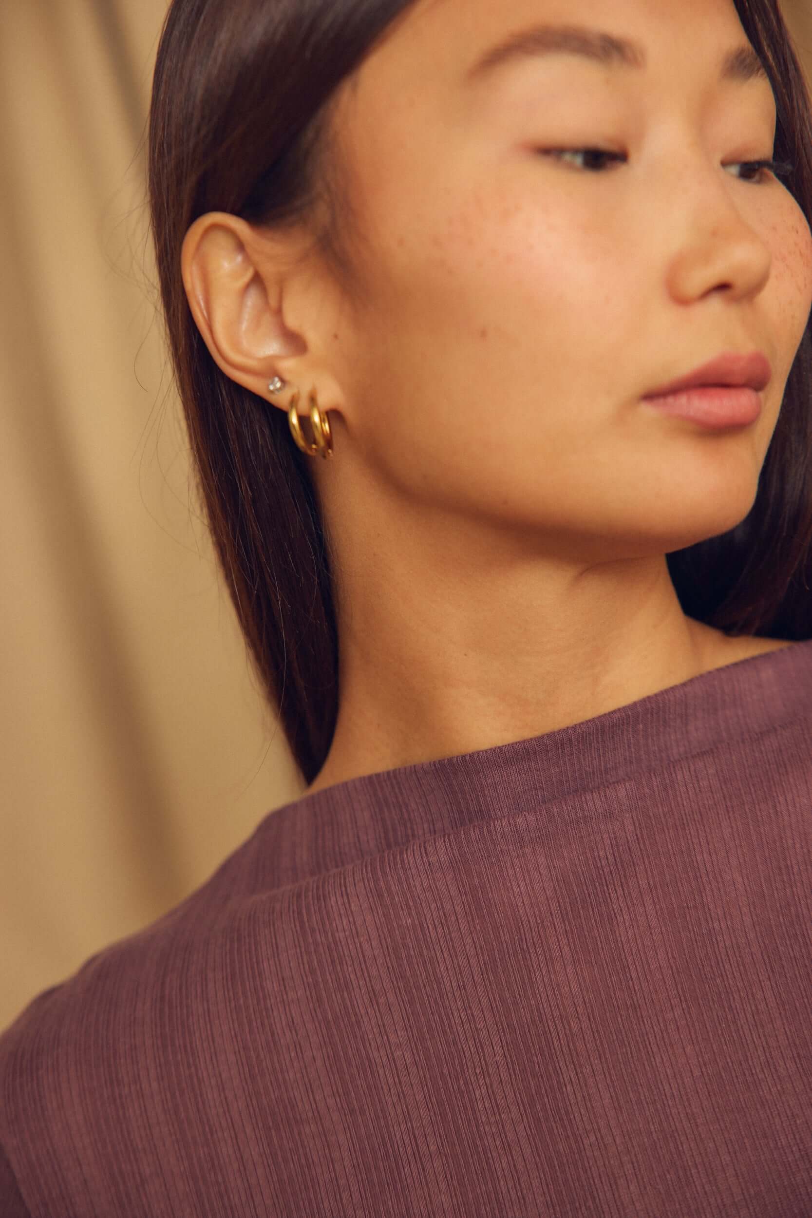 Close-up of woman wearing gold hoop earrings and a Cocoa Lyocell Ribbed Long Sleeve Top in rich cocoa brown.