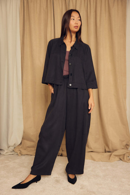 Model wearing a Black Lyocell Flared Jacket with stylish loose pants in a neutral setting.