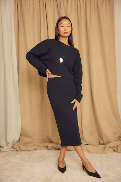 Model wearing a Black Organic Cotton Oversized Crop Top with a matching skirt against a neutral backdrop.
