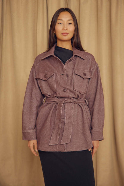 Model wearing Cocoa Organic Cotton Shacket with a belt over a black dress, styled against a neutral backdrop.