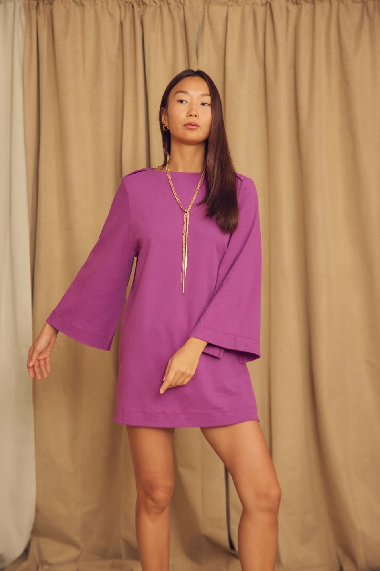 Model wearing a Plum Organic Cotton Mini Dress with Flared Sleeves in a studio setting.