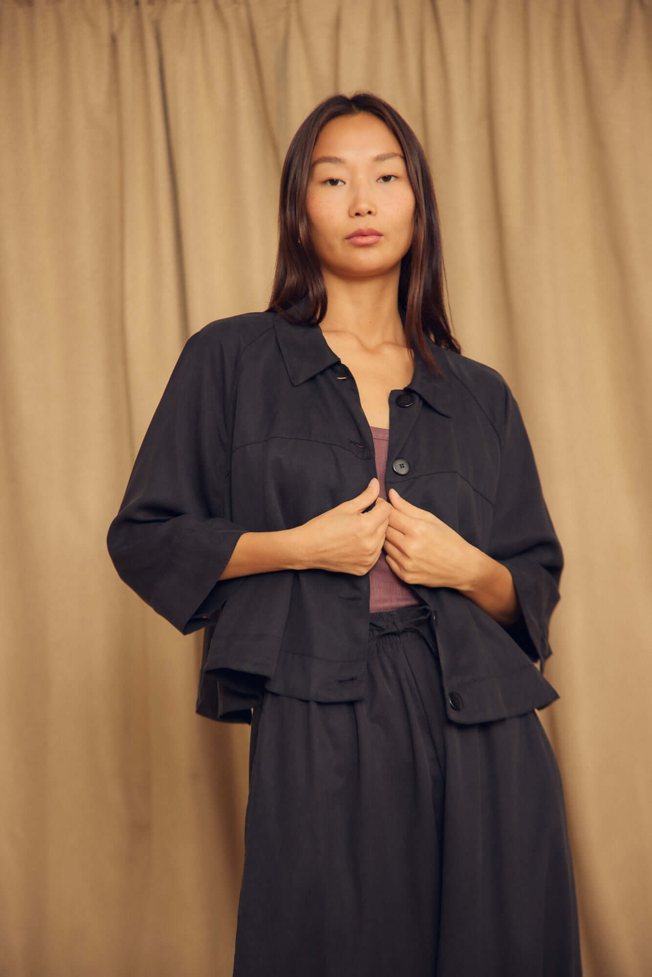 Model wearing a Black Lyocell Flared Jacket, showcasing its elegant flared silhouette and structured design.