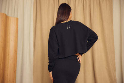 Model wearing Black Organic Cotton Oversized Crop Top, showcasing the relaxed fit and contemporary style from the back view.
