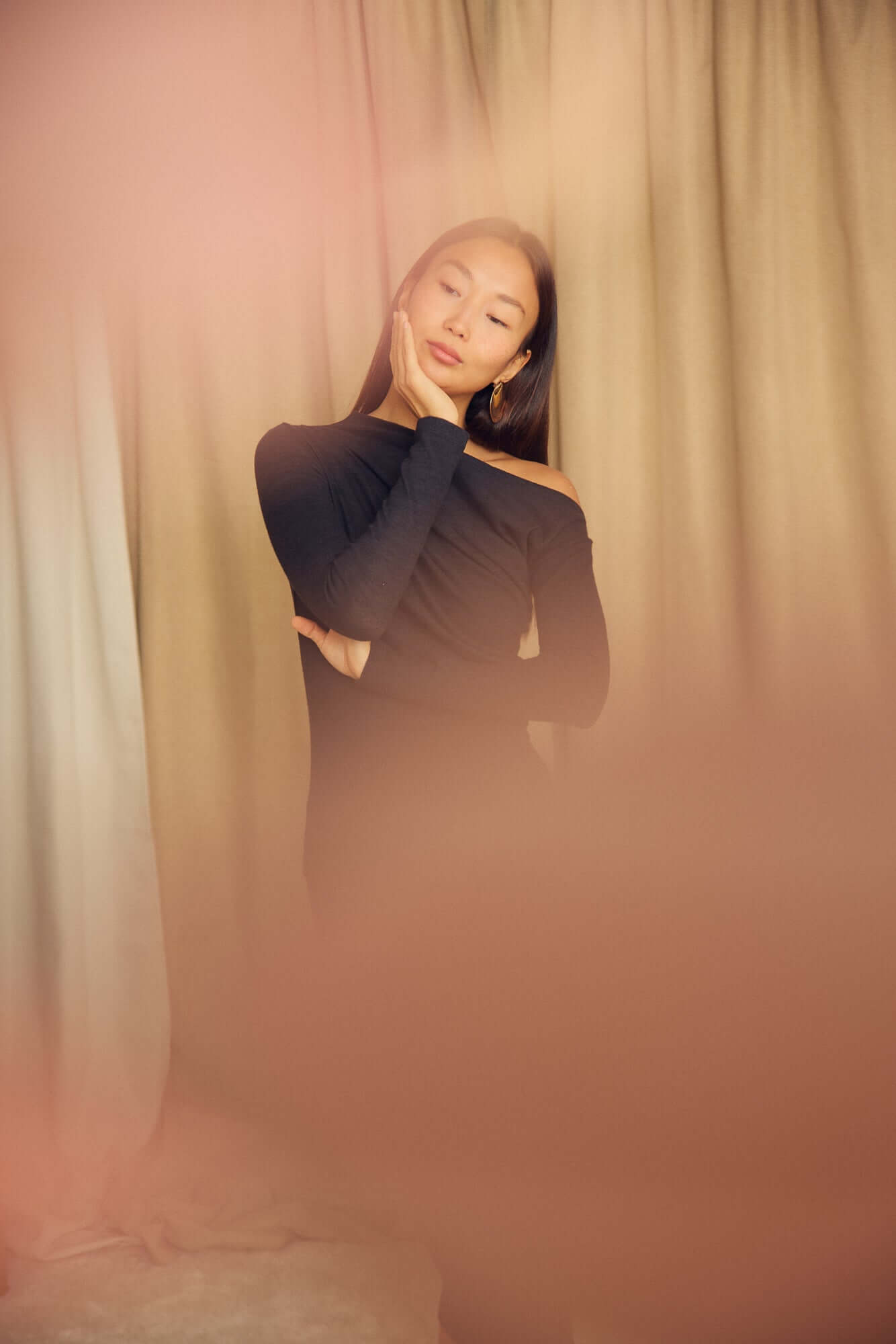 Model showcasing the Black Wool Drape Top with thumb holes, featuring an elegant neckline and soft fit.