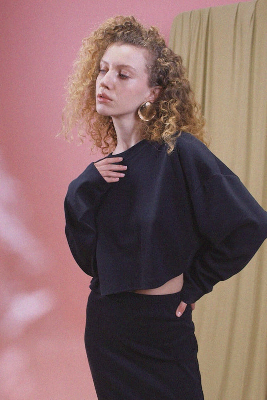 Model wearing an Organic Cotton Long Sleeve Top in Black, showcasing its oversized cropped silhouette.