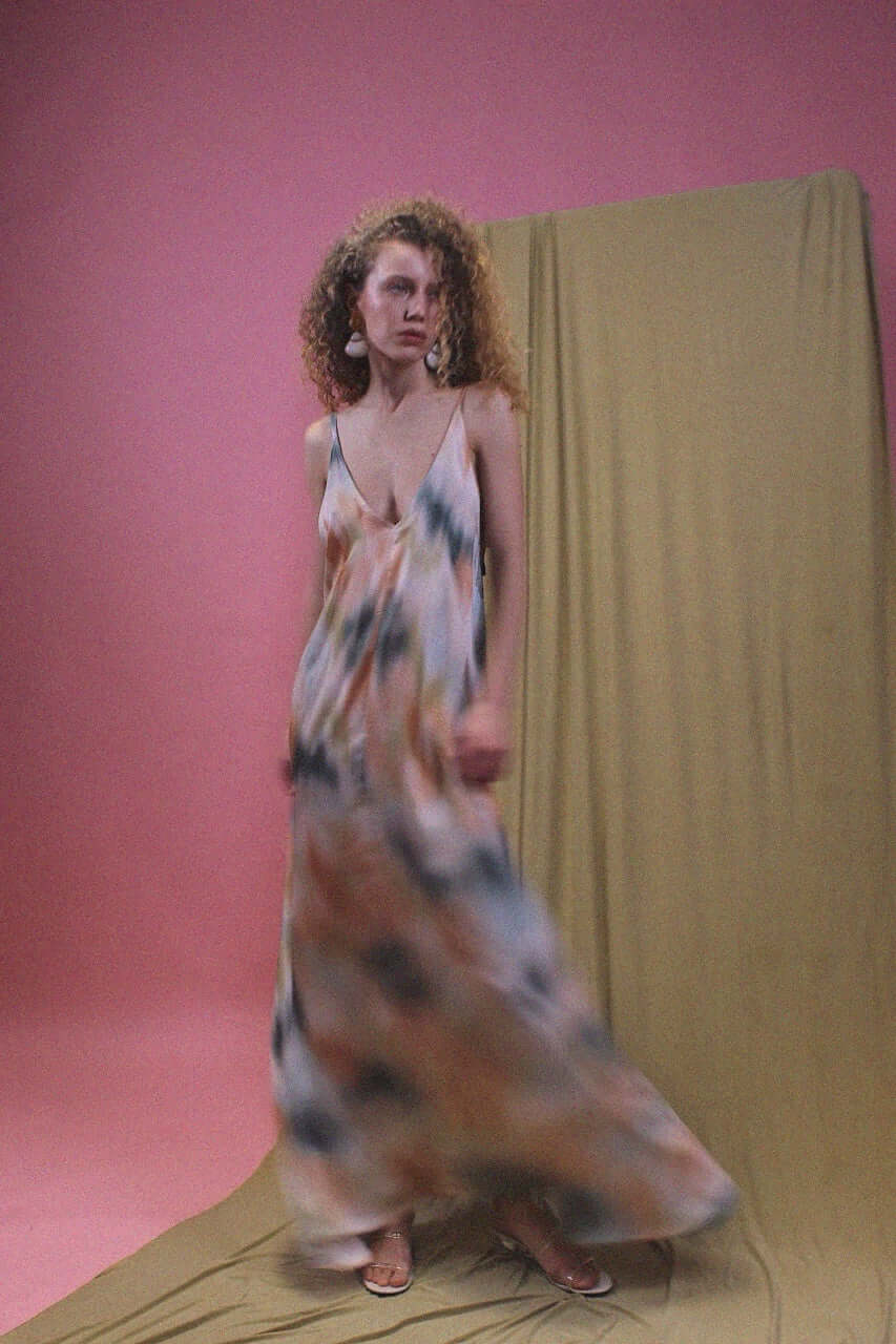 Model wearing a Printed Ecovero Viscose Maxi Dress, showcasing fluid motion against a pink backdrop.