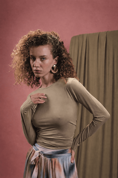 Model wearing the Cupro Multiway Wrap Top in Soft Olive, showcasing a versatile and elegant style.