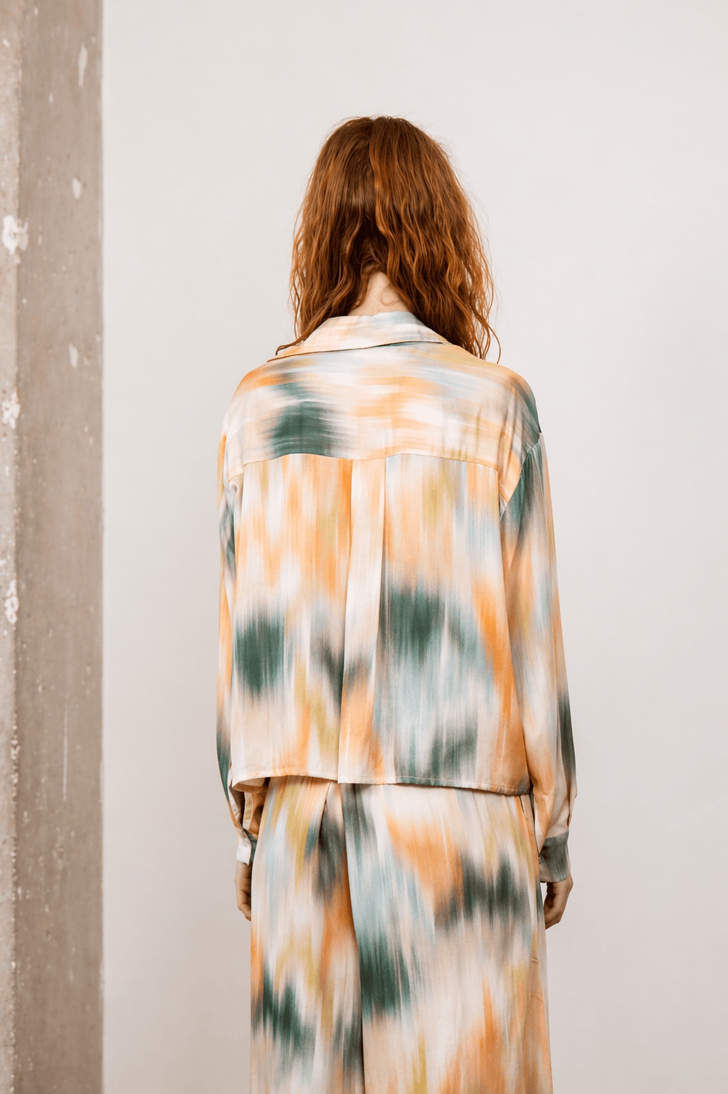 Back view of a woman wearing a Printed Cropped Ecovero Viscose Oversized Shirt in colorful print.