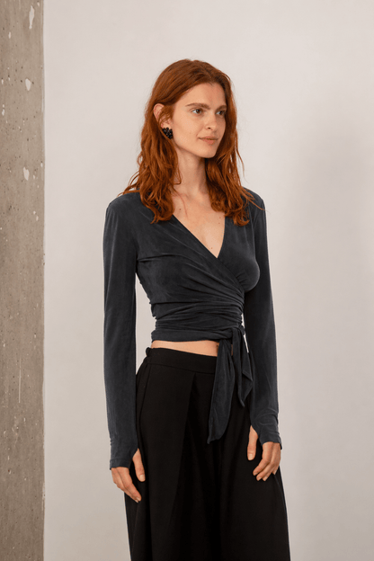 Cupro Multiway Wrap Top in Slate Black worn by a model, featuring a sleek wrap design and long sleeves.