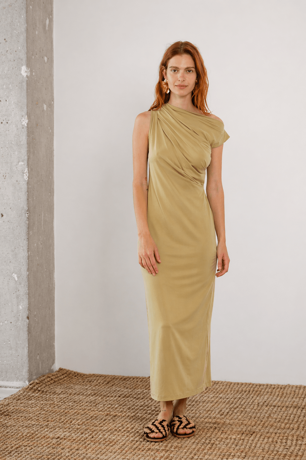 Drape Cupro Midi Dress in Olive worn by a model, showcasing its elegant draped neckline and smooth jersey fabric.