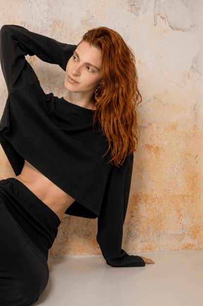 Organic Cotton Long Sleeve Top in Black worn by a model, showcasing relaxed fit and oversized cropped design.