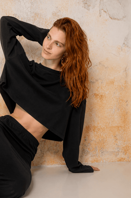 Organic Cotton Long Sleeve Top in Black worn by a model, showcasing relaxed fit and oversized cropped design.