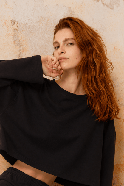 Model showcasing Organic Cotton Long Sleeve Top in Black with a relaxed fit and oversized silhouette.