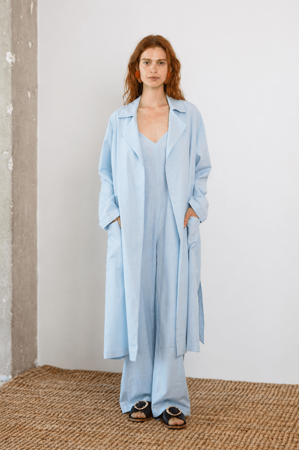 Lightweight Organic Cotton Trench Coat in Pale Blue modeled by a woman in a relaxed fit, showcasing its versatile design.