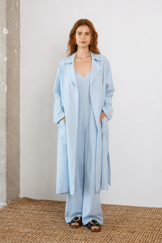 Lightweight Organic Cotton Trench Coat in Pale Blue modeled by a woman in a relaxed fit, showcasing its versatile design.