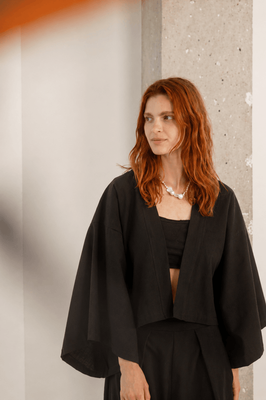 Organic Cotton Kimono Jacket in Black worn by a model with wavy hair, styled for a modern look.