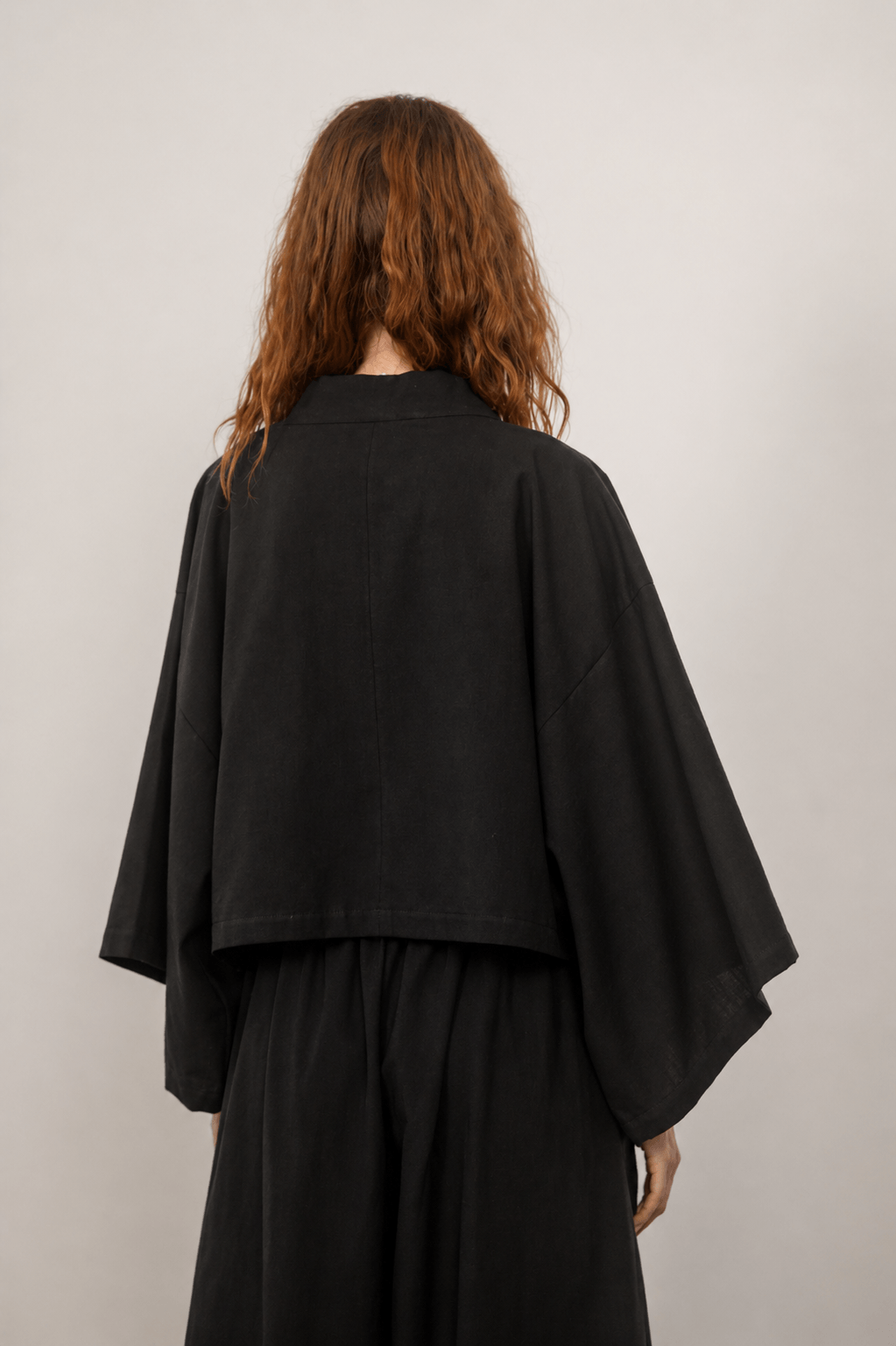 Back view of the Organic Cotton Kimono Jacket in Black, showcasing its relaxed silhouette and oversized design.