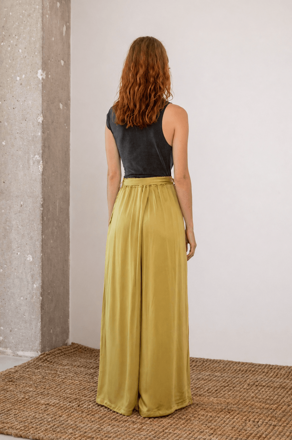 Wide Ecovero Trousers in Soft Olive, showcasing a relaxed fit and silky drape from the back view.