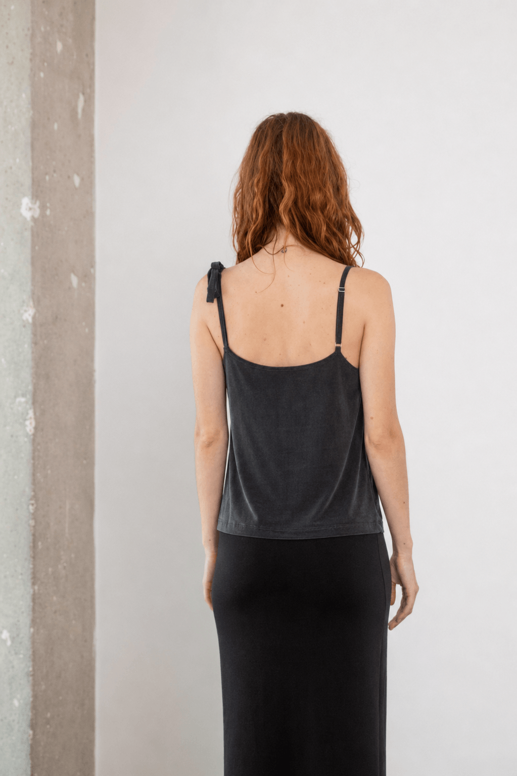 Model wearing the Cupro Drape Slip Top in Soft Olive from the back, showcasing its adjustable straps.