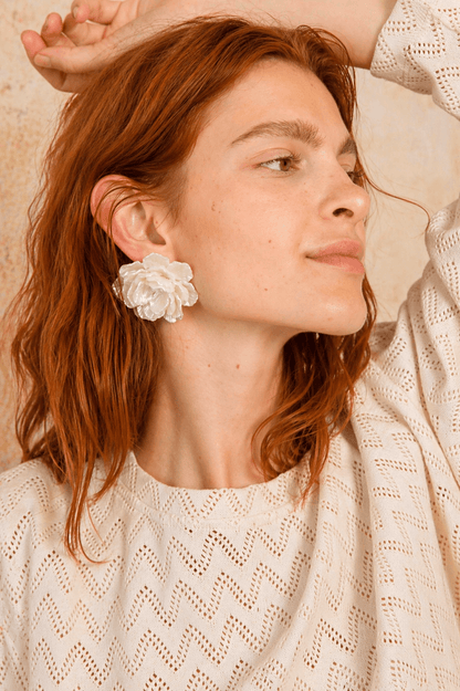 Model showcasing a Crochet Organic Cotton Long Sleeve Top with a floral earring, highlighting a textured, casual outfit.