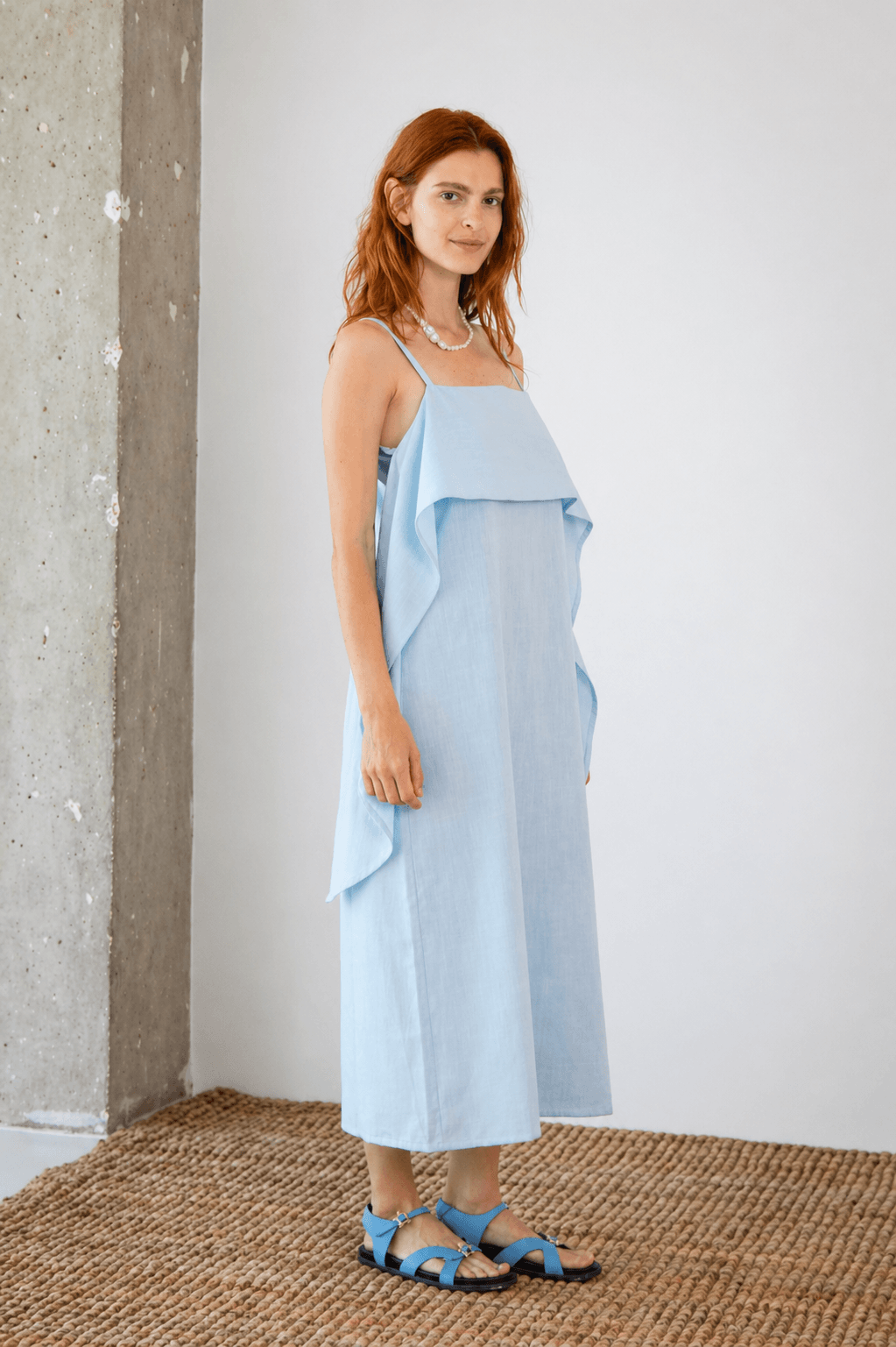 Organic Cotton Sun Dress with Front Frill in Pale Blue worn by a model standing against a minimal background.