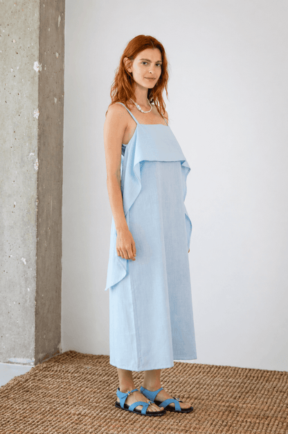 Organic Cotton Sun Dress with Front Frill in Pale Blue worn by a model standing against a minimal background.