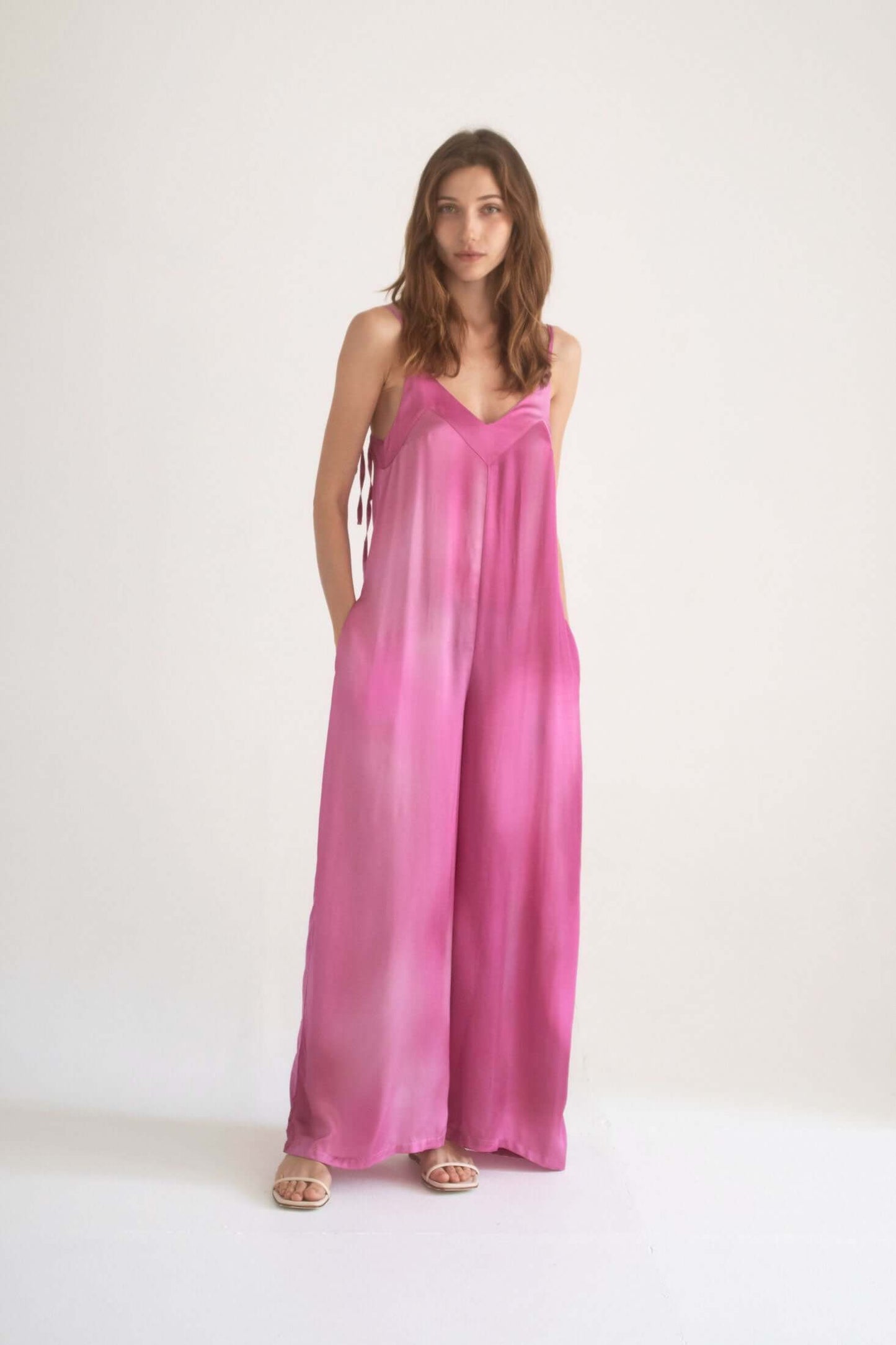 PRINT WIDE JUMPSUIT in pink, featuring adjustable straps and side pockets, model wearing size S.