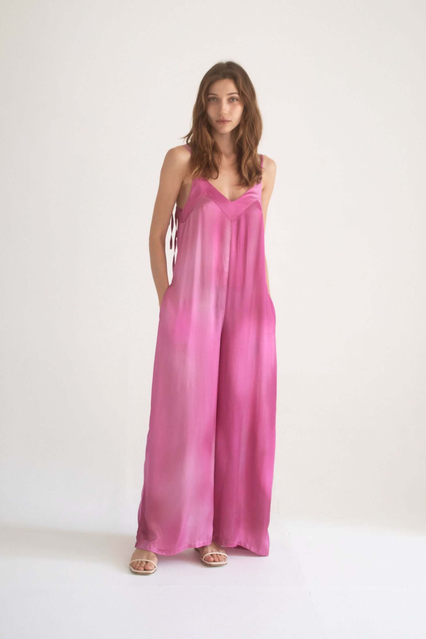 PRINT WIDE JUMPSUIT in pink, featuring adjustable straps and side pockets, model wearing size S.