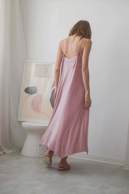 Back view of a model in a ROSE CUPRO MIDI DRESS with adjustable straps, showcasing sustainable summer elegance.