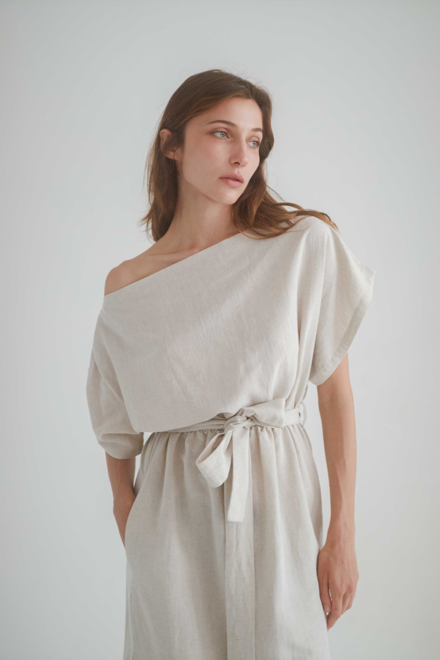 Natural drape dress with off-shoulder neckline, elasticated waist, and a separate belt, made from organic cotton and linen.