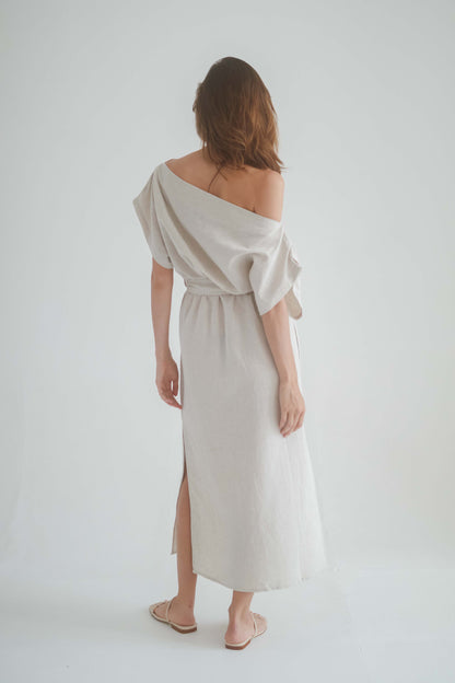 Woman wearing a natural drape dress with off-shoulder neckline and midi length, showcasing a relaxed yet elegant style.