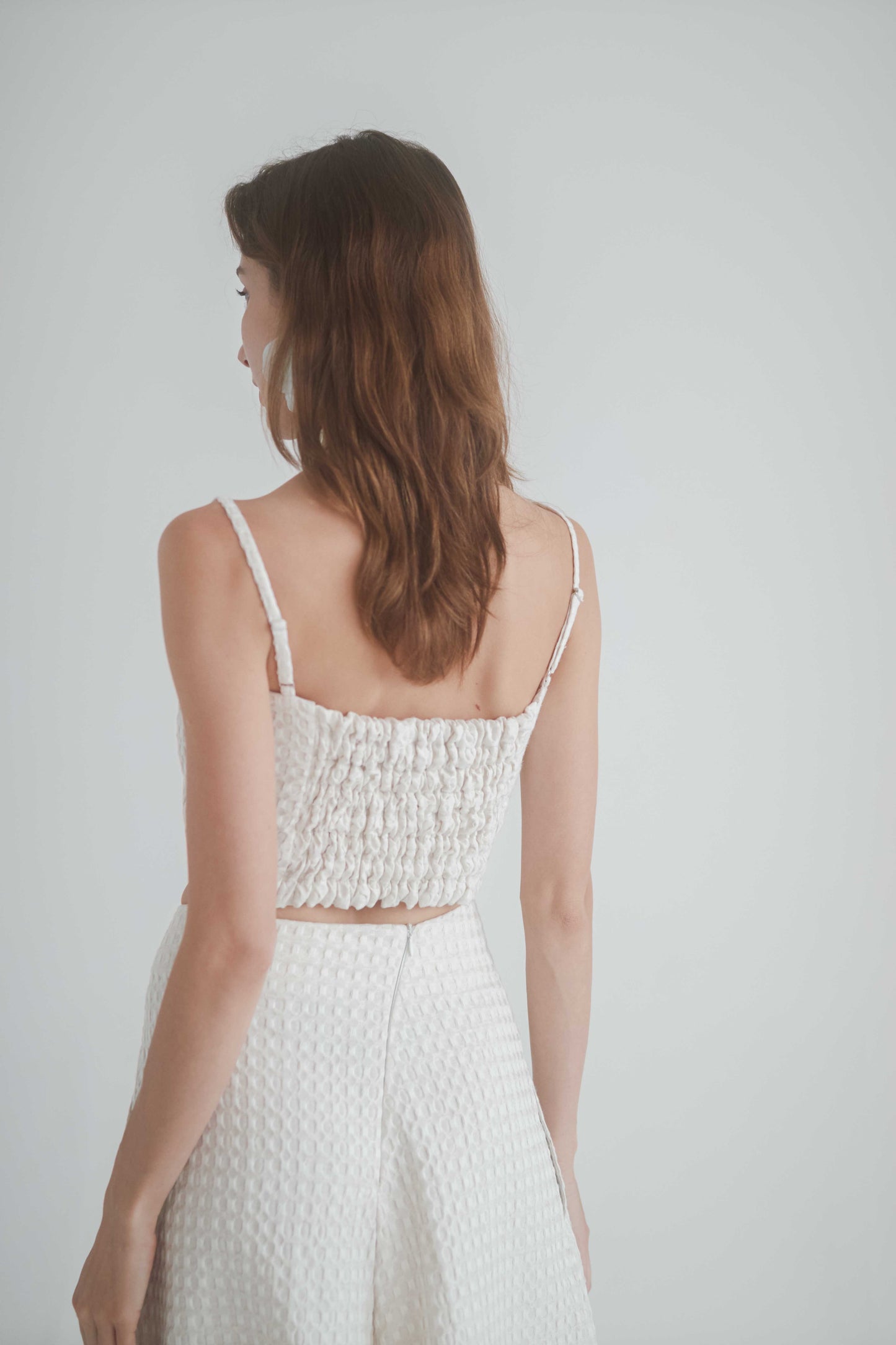 ECRU WAFFLE CROP TOP showcasing adjustable straps and shirred back design, perfect for summer styling.
