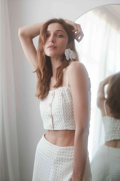 ECRU WAFFLE CROP TOP styled with adjustable straps and a shirred back, perfect for summer fashion.
