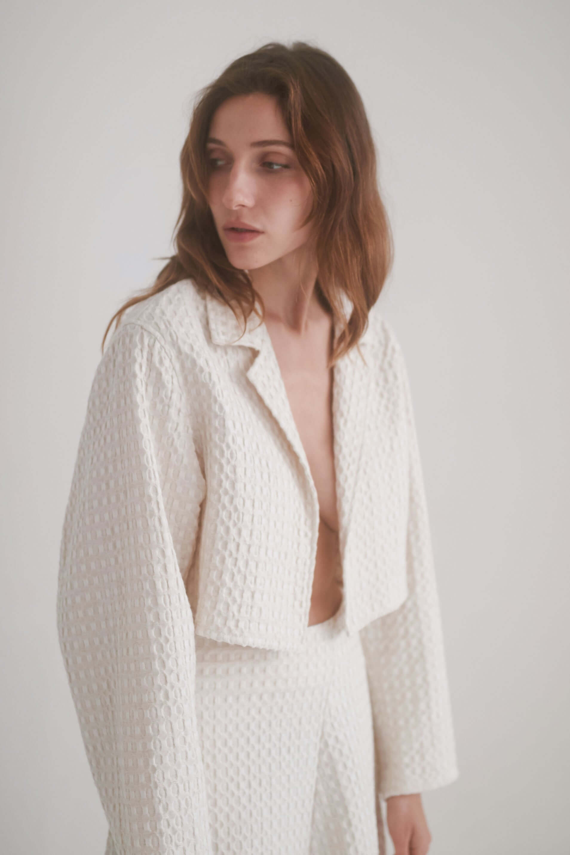 ECRU WAFFLE CROP JACKET worn by a model, featuring a stylish lightweight design and waffle textured fabric.