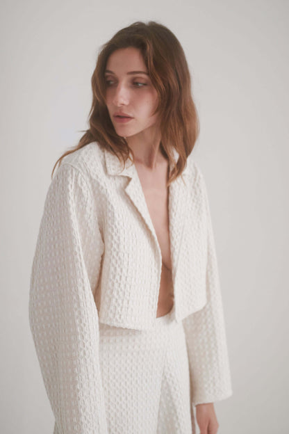 ECRU WAFFLE CROP JACKET worn by a model, featuring a stylish lightweight design and waffle textured fabric.