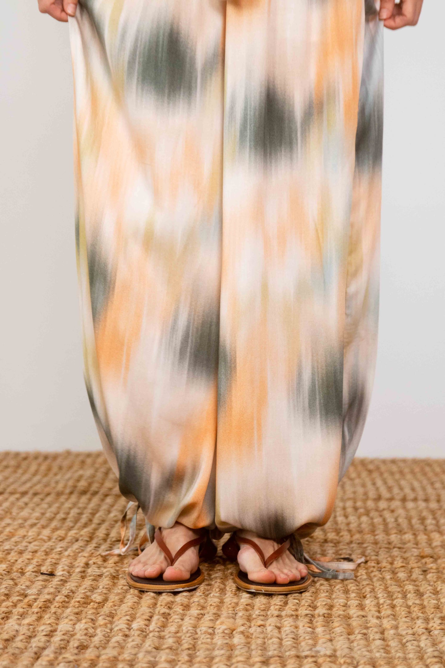 Model wearing Printed Ecovero Viscose Wide-Leg Trousers with a colorful pattern and sandals, showcasing relaxed style.