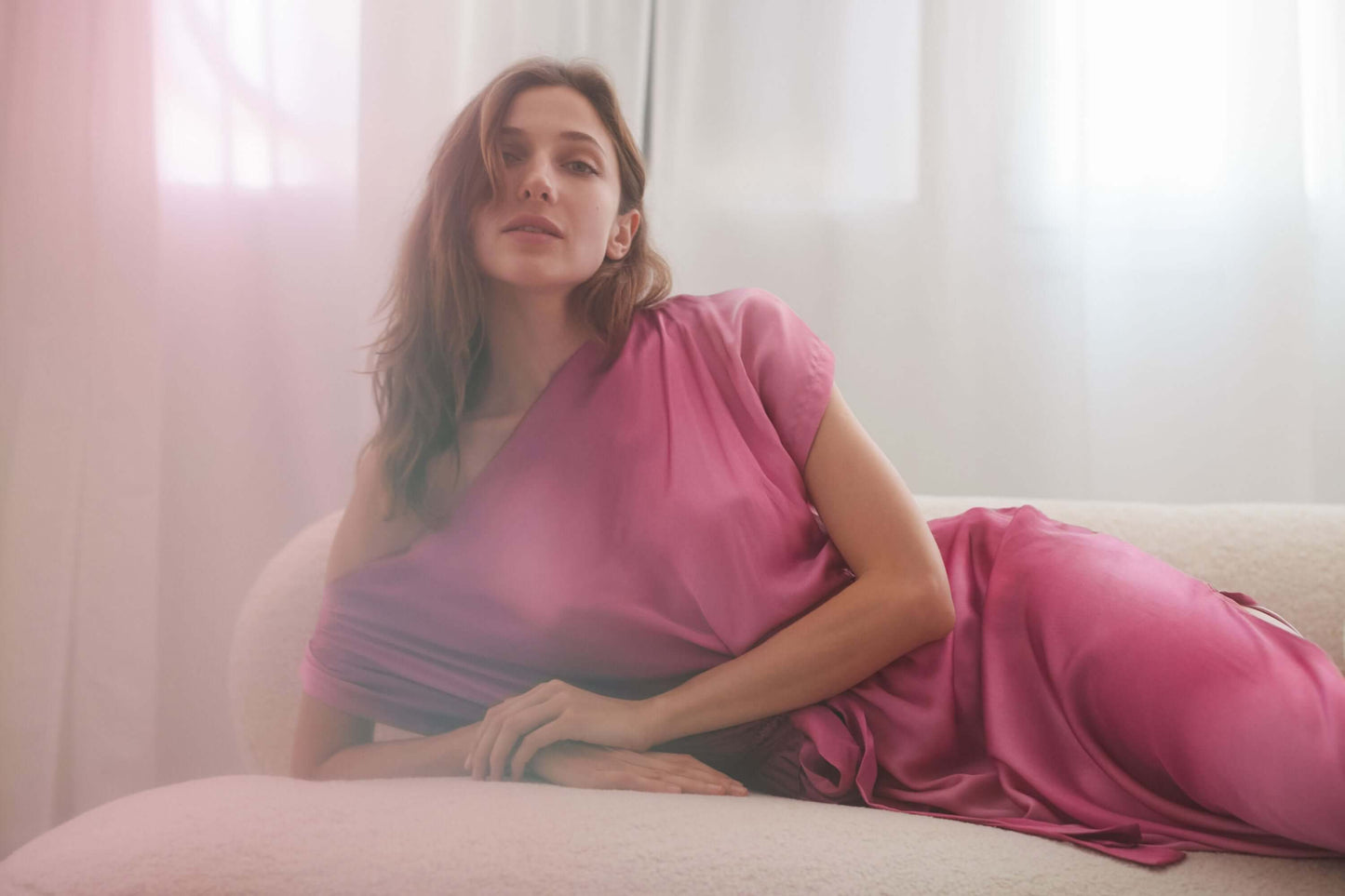 Model wearing pink off-shoulder drape dress, showcasing its elegant design and soft fabric.