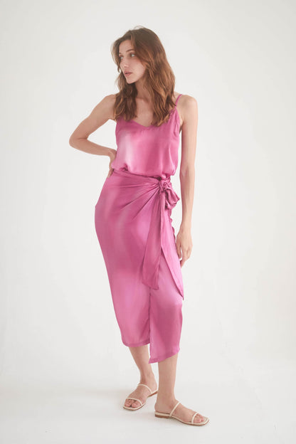Model wearing a pink printed wrap midi skirt with a self-tie closure, showcasing stylish and versatile fashion.