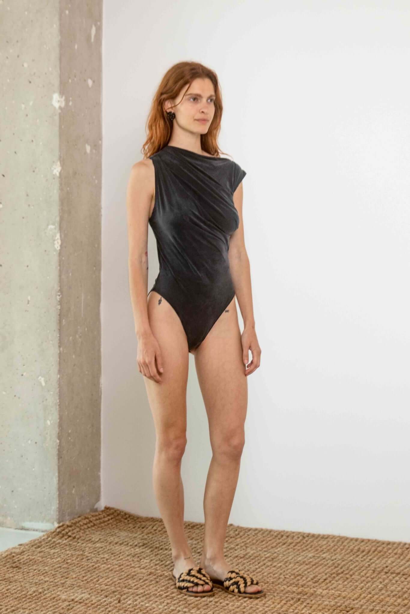 Drape Neckline Bodysuit in Slate Black worn by model, showcasing its sculpted design and sleek fabric fit.