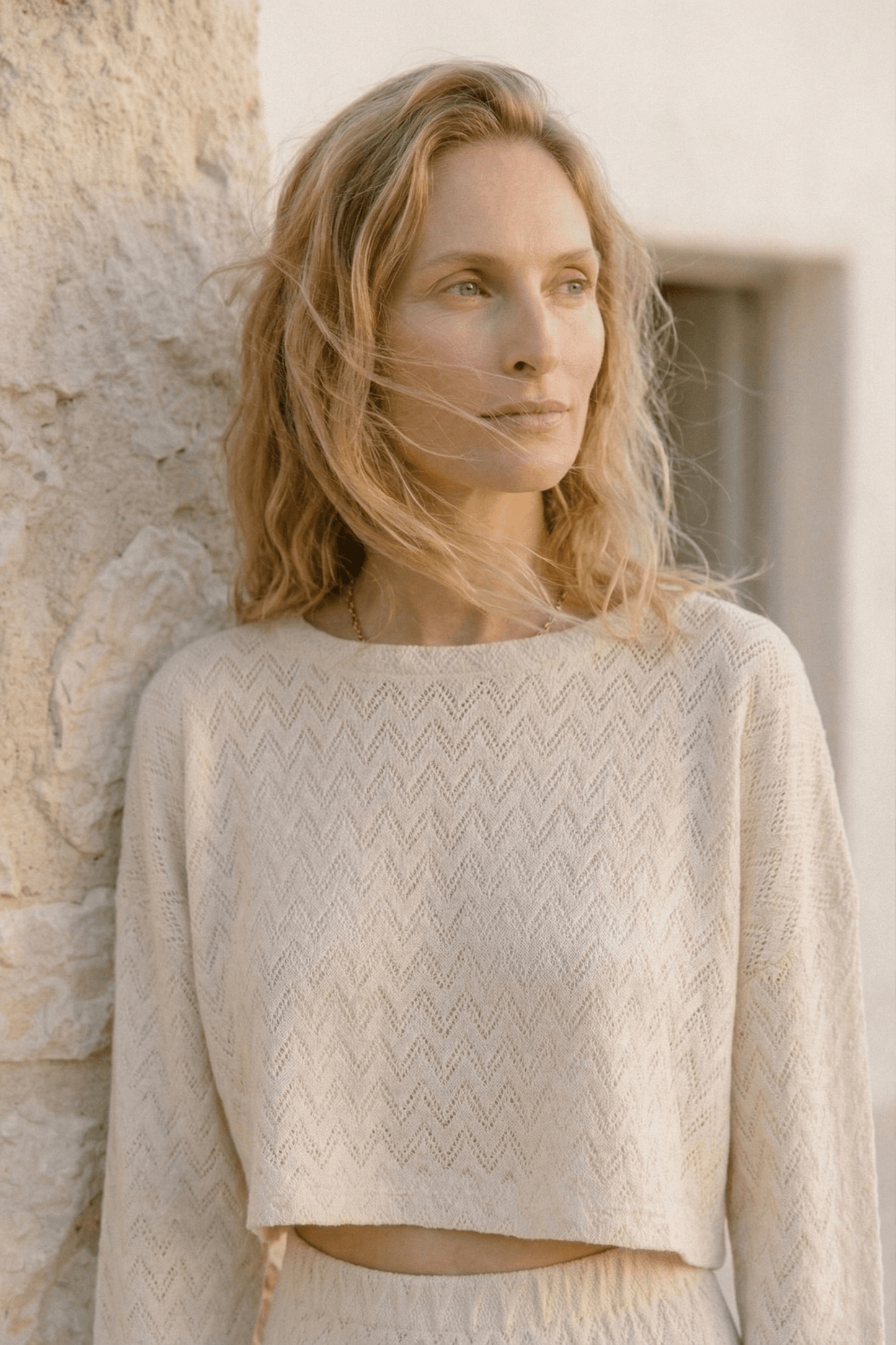 Model wearing a Crochet Organic Cotton Long Sleeve Top in ecru, showcasing its textured crochet design and oversized silhouette.
