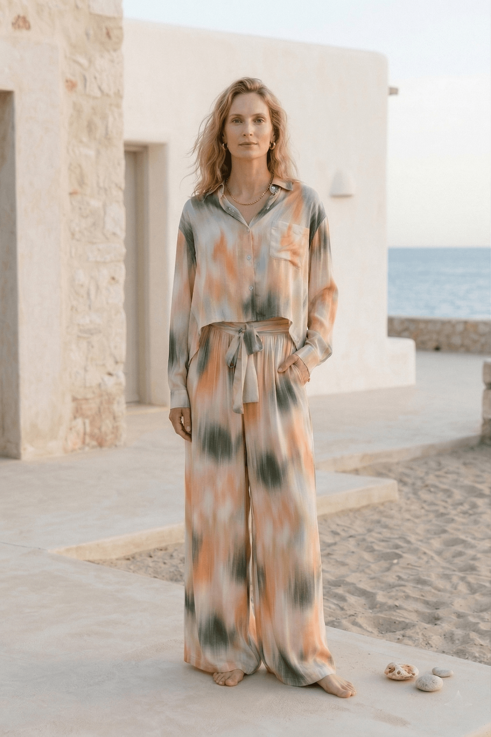Model wearing Printed Ecovero Viscose Wide-Leg Trousers in a seasonal print by the beach.