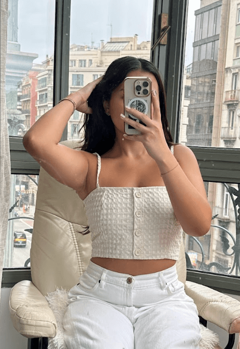 ECRU WAFFLE CROP TOP worn by a woman in front of a window, showcasing its breathable design and adjustable straps.