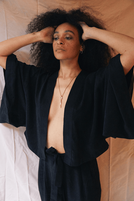 Model wearing an Organic Cotton Kimono Jacket in Black, showcasing its relaxed silhouette and oversized design.