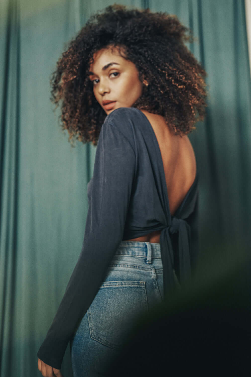 Model wearing Cupro Multiway Wrap Top in Slate Black, showcasing its back design and elegant fit.